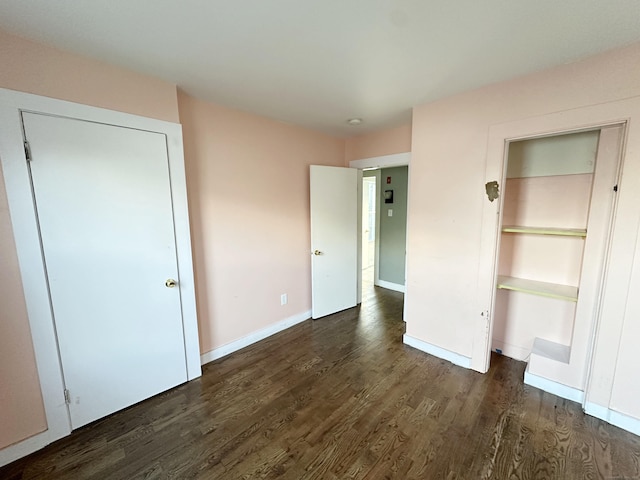 unfurnished bedroom featuring dark hardwood / wood-style floors and a closet