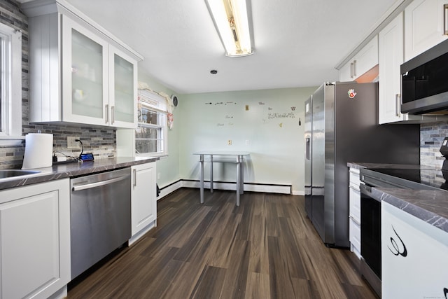 kitchen with decorative backsplash, appliances with stainless steel finishes, a baseboard radiator, dark hardwood / wood-style floors, and white cabinetry