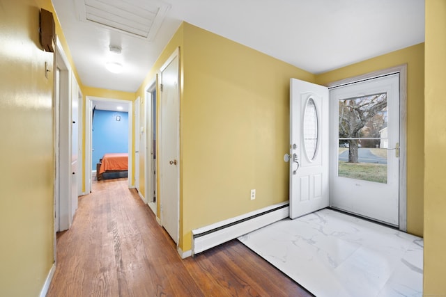 foyer with light wood-type flooring and a baseboard heating unit