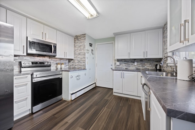 kitchen with dark hardwood / wood-style flooring, stainless steel appliances, sink, a baseboard radiator, and white cabinetry