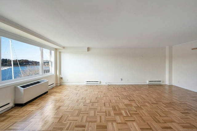 empty room featuring light parquet floors, radiator, and a baseboard heating unit