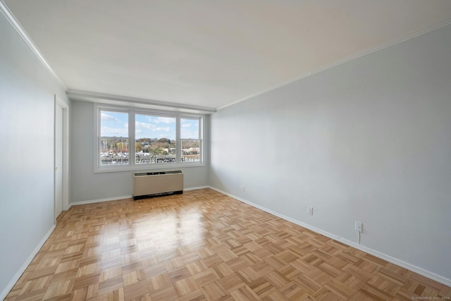 spare room with light parquet floors, radiator, and crown molding