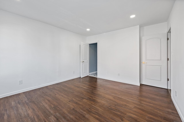 unfurnished room with dark wood-type flooring