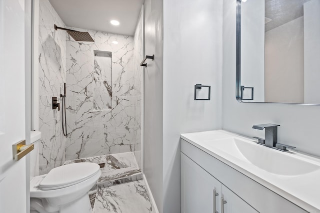 bathroom featuring toilet, vanity, and tiled shower