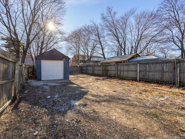 view of yard with a garage and an outbuilding