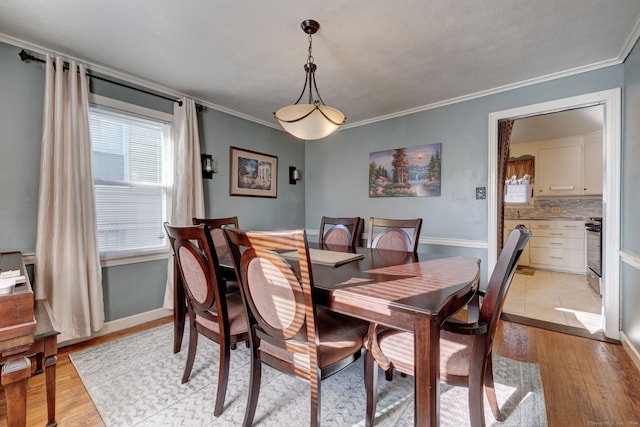 dining room with light hardwood / wood-style floors and crown molding