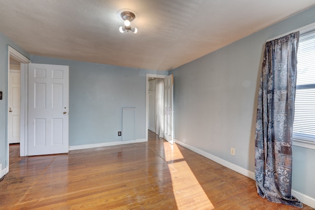 spare room with a textured ceiling and hardwood / wood-style flooring