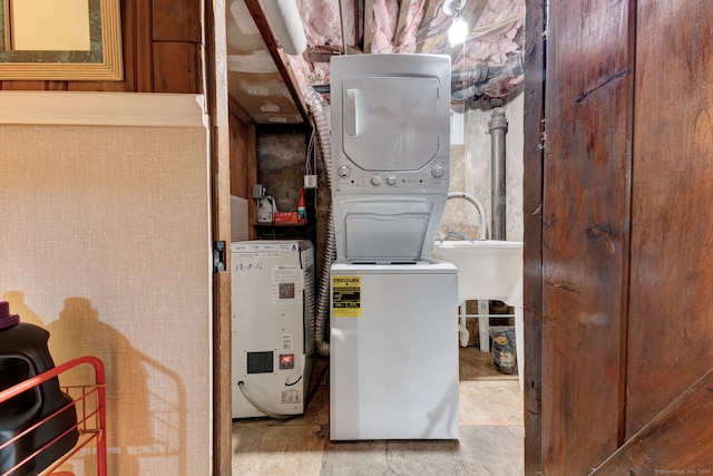 utility room with stacked washer and clothes dryer