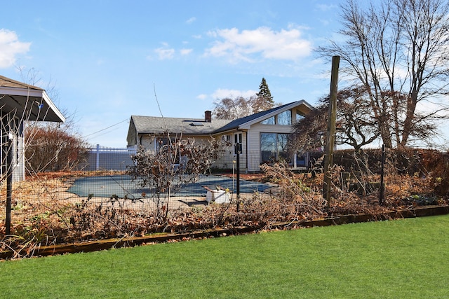 back of property featuring a patio area, a yard, and a covered pool