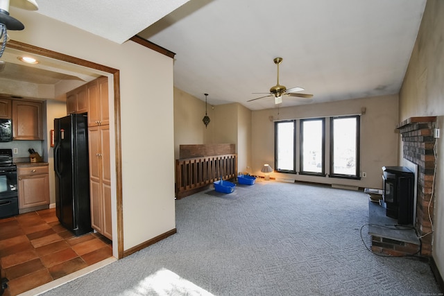 living room with dark colored carpet, ceiling fan, and a wood stove