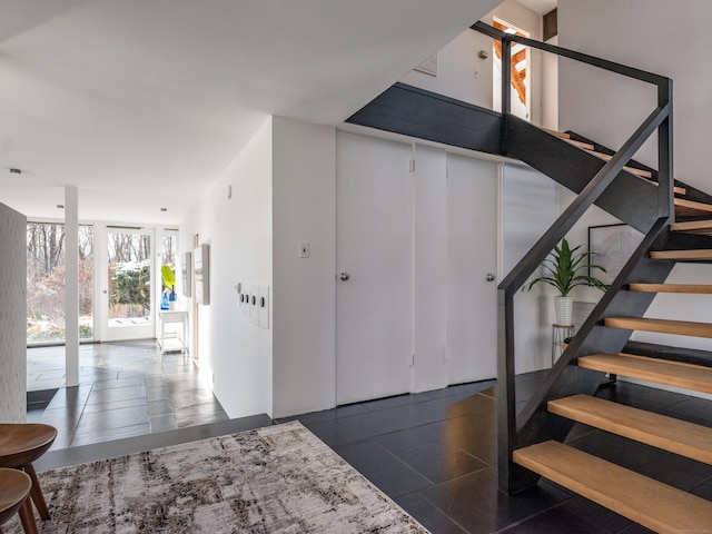 staircase featuring a wall of windows