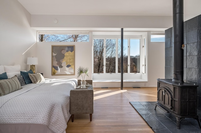 bedroom with hardwood / wood-style flooring and a wood stove