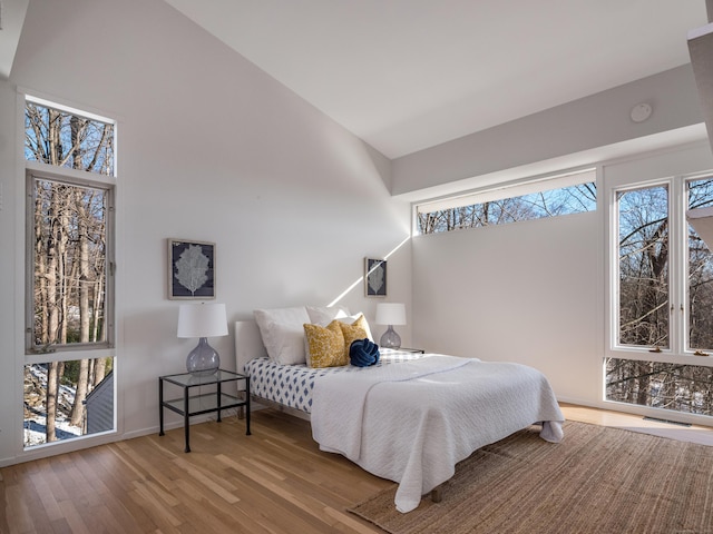 bedroom with wood-type flooring and multiple windows