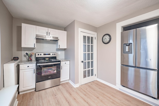 kitchen featuring decorative backsplash, light wood-type flooring, a textured ceiling, white cabinetry, and stainless steel appliances