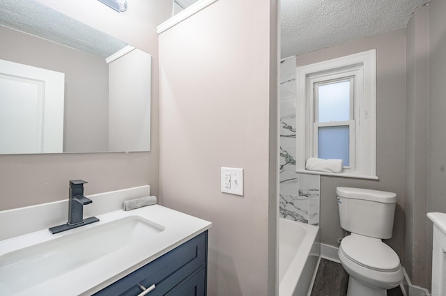 full bathroom featuring vanity, a textured ceiling, hardwood / wood-style flooring, toilet, and tiled shower / bath