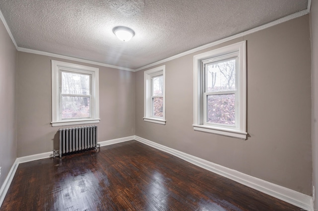 empty room with dark hardwood / wood-style flooring, ornamental molding, a textured ceiling, and radiator