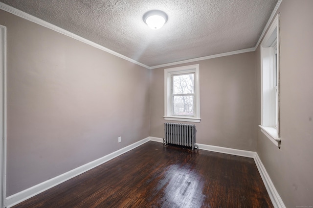 spare room with a textured ceiling, crown molding, radiator heating unit, and dark wood-type flooring