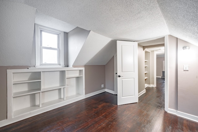 bonus room with dark hardwood / wood-style floors, a textured ceiling, and vaulted ceiling