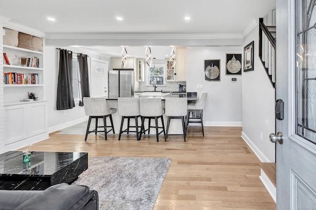 interior space with ornamental molding and light hardwood / wood-style flooring