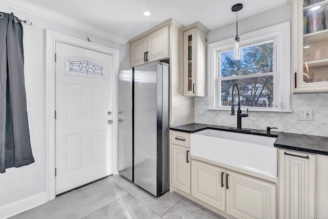 kitchen with tasteful backsplash, cream cabinets, decorative light fixtures, and sink