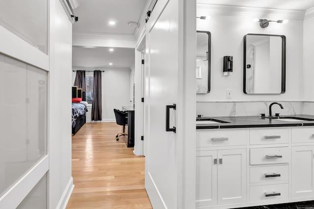 interior space with hardwood / wood-style flooring, vanity, and crown molding