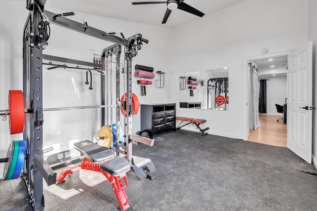 exercise room with ceiling fan and dark wood-type flooring