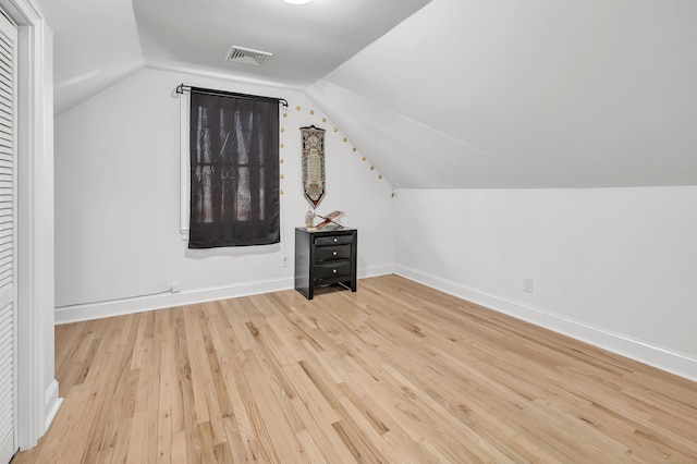 bonus room with vaulted ceiling and light wood-type flooring