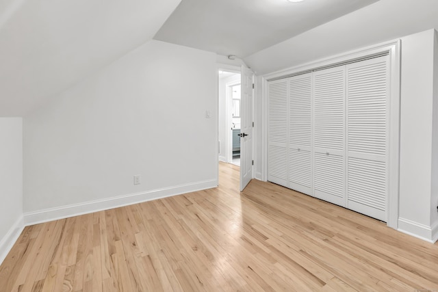 additional living space featuring vaulted ceiling and light hardwood / wood-style flooring