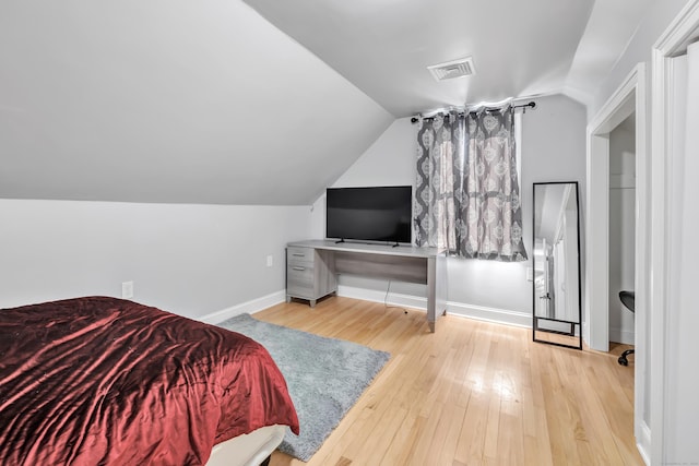 bedroom with hardwood / wood-style flooring and lofted ceiling