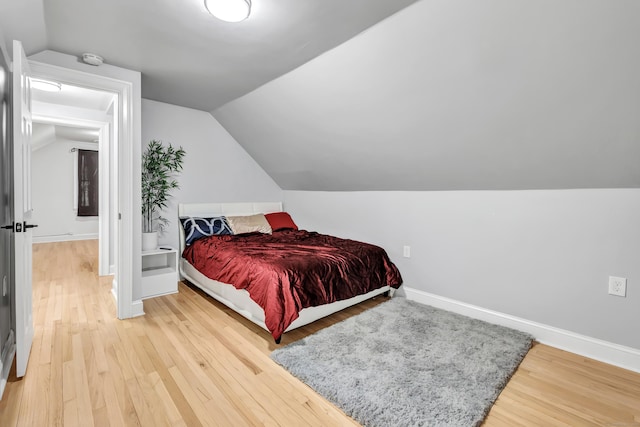 bedroom with hardwood / wood-style flooring and lofted ceiling