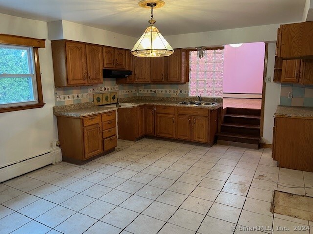 kitchen featuring sink, hanging light fixtures, decorative backsplash, light tile patterned floors, and exhaust hood