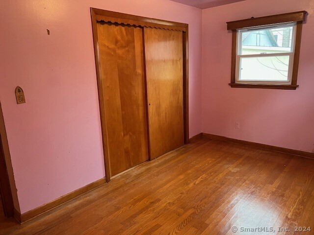 unfurnished bedroom with a closet and light wood-type flooring