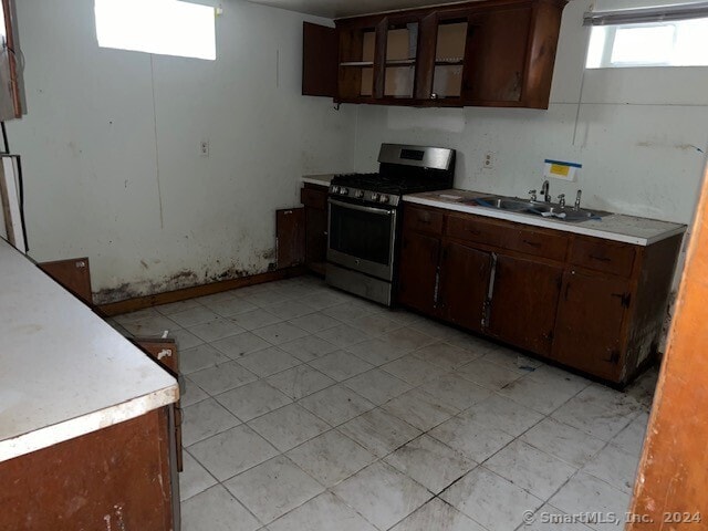 kitchen featuring dark brown cabinetry, sink, and stainless steel gas range