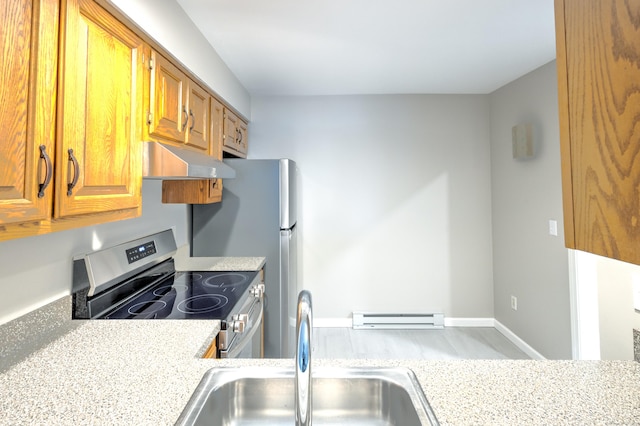 kitchen featuring light stone counters, stainless steel range, a baseboard radiator, and sink