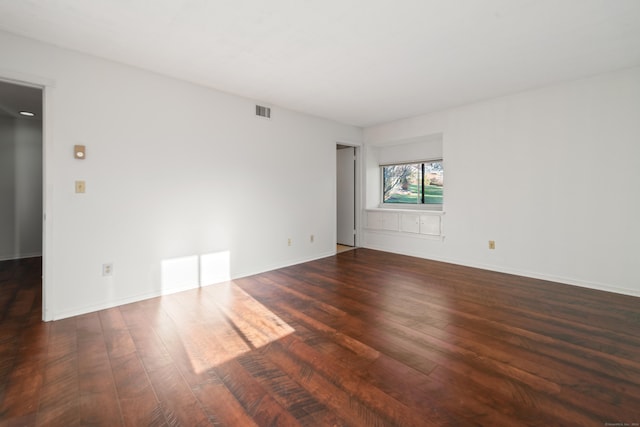 spare room featuring dark wood-type flooring