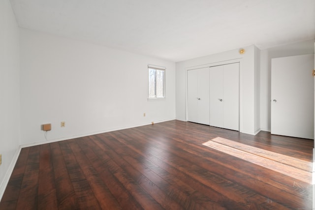 unfurnished bedroom with a closet and dark wood-type flooring