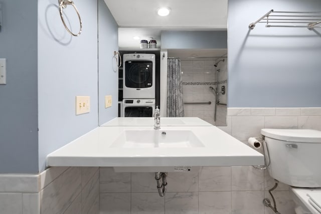 bathroom with stacked washer and dryer, toilet, and curtained shower