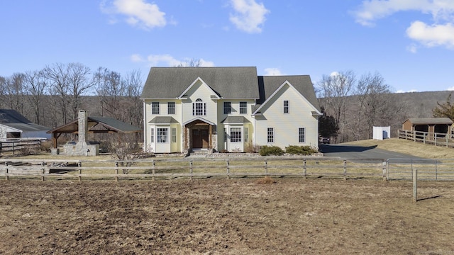 view of front of house with a fenced front yard and an outbuilding