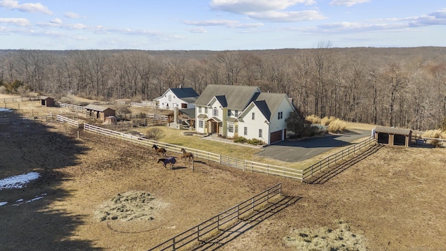 drone / aerial view with a wooded view and a rural view