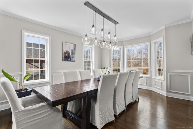 dining area with dark wood-style flooring, a wainscoted wall, crown molding, and a decorative wall