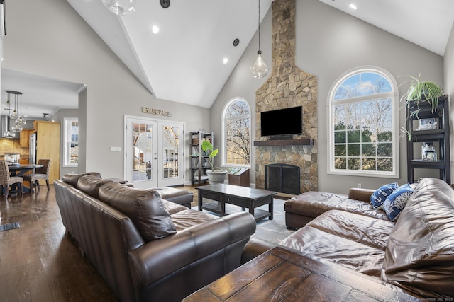 living room featuring high vaulted ceiling, a fireplace, wood finished floors, and recessed lighting