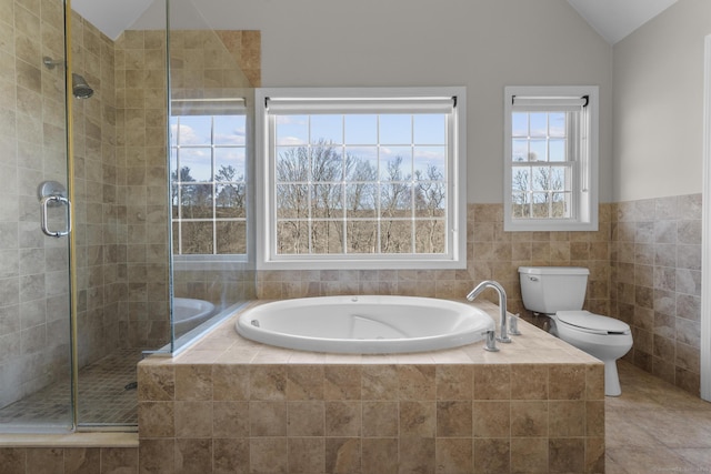 full bathroom featuring lofted ceiling, a garden tub, a shower stall, and toilet