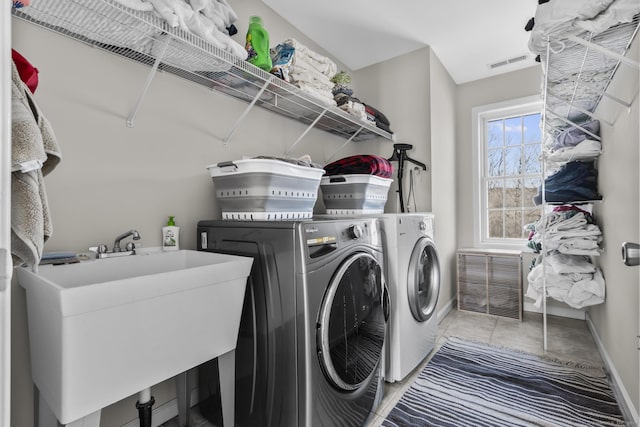 laundry area featuring laundry area, washing machine and dryer, visible vents, and a sink