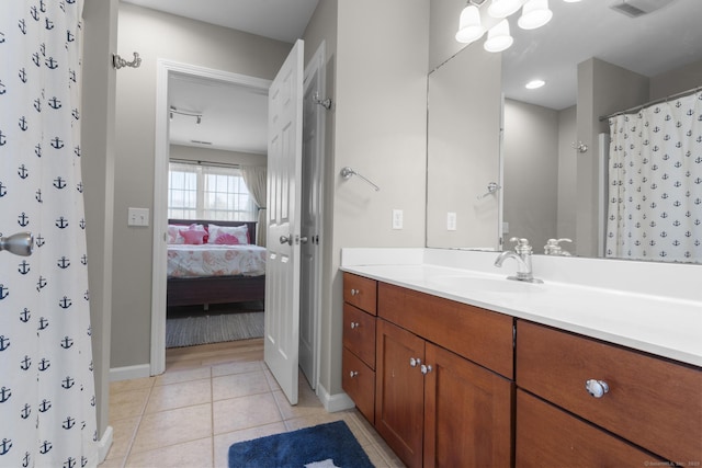 full bath featuring ensuite bathroom, baseboards, vanity, and tile patterned floors