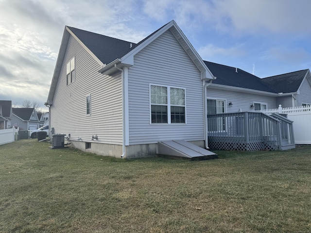 back of property with a yard, a deck, and central air condition unit