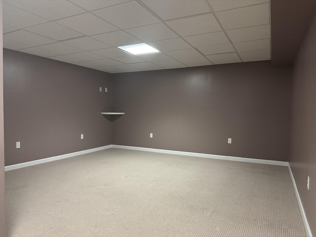 spare room with a paneled ceiling and carpet flooring