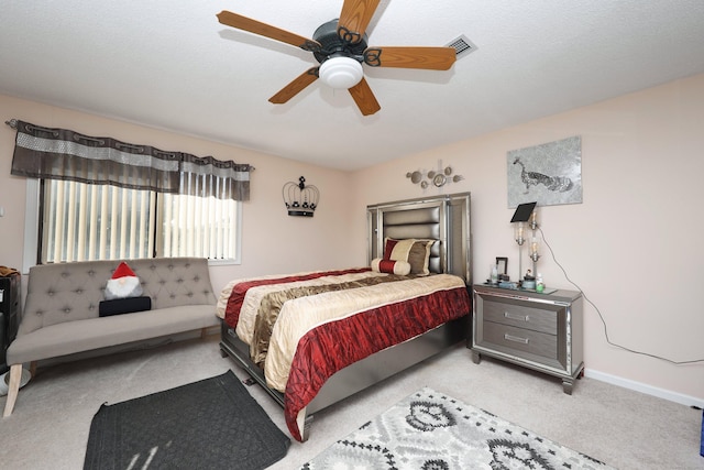 carpeted bedroom featuring ceiling fan and a textured ceiling