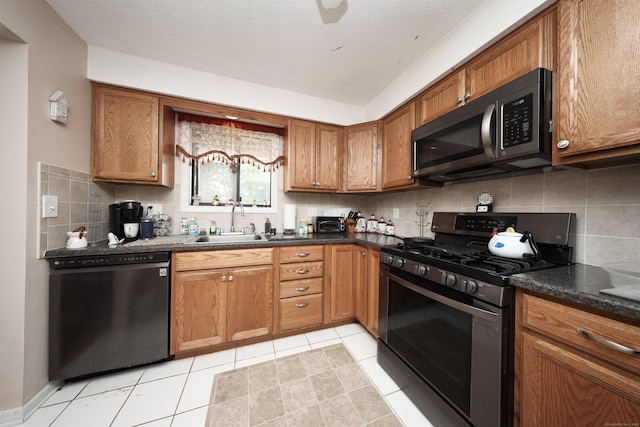 kitchen featuring black appliances, decorative backsplash, light tile patterned floors, and sink