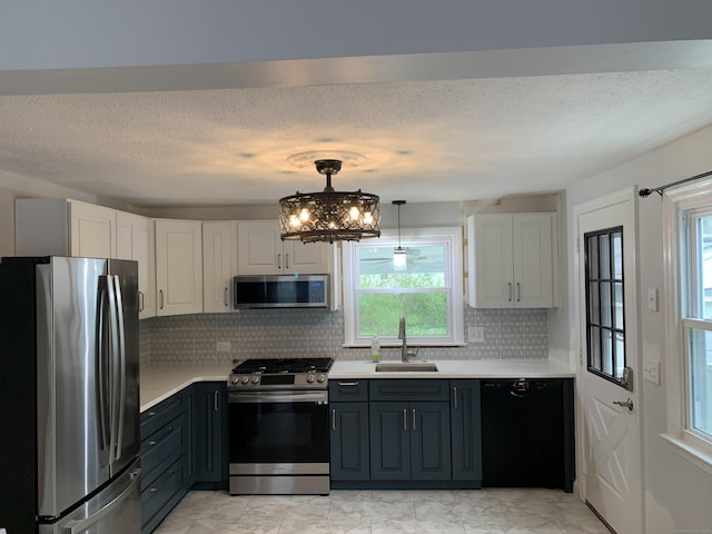 31 Gary Dr, Enfield, CT 06082 - kitchen with stainless steel appliances, a sink, light countertops, decorative backsplash, and a chandelier