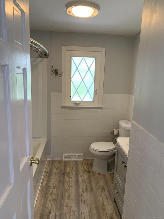 31 Gary Dr, Enfield, CT 06082 - full bath featuring tile walls, wood finished floors, toilet, wainscoting, and vanity